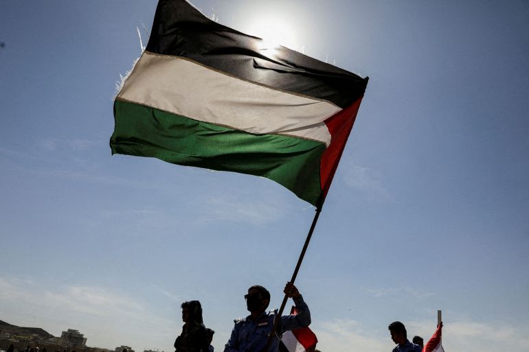 FILE PHOTO: Houthi followers hold a Palestinian flag during a parade in solidarity with the Palestinians in the Gaza Strip and to show support to Houthi strikes on ships in the Red Sea and the Gulf of Aden, in Sanaa, Yemen January 29, 2024. REUTERS/Khaled Abdullah//File Photo