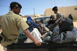Foreign nationals accused of trying to migrate towards Europe are transported in a car by Mauritanian police officials in Nouadhibou before being expelled from the country on May 23, 2006. [File: Reuteres/Juan Medina]