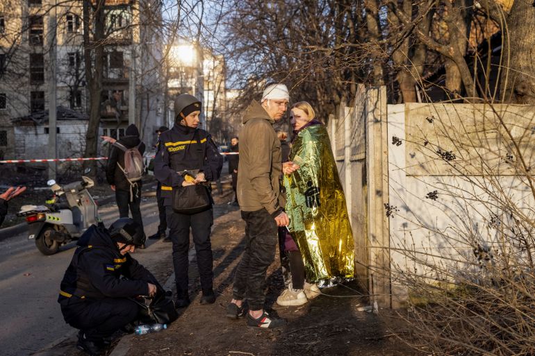 Wounded local residents stand at the site where buildings were damaged by a Russian military strike, amid Russia's attack on Ukraine, in Kharkiv, Ukraine March 27, 2024. REUTERS/Yevhen Titov