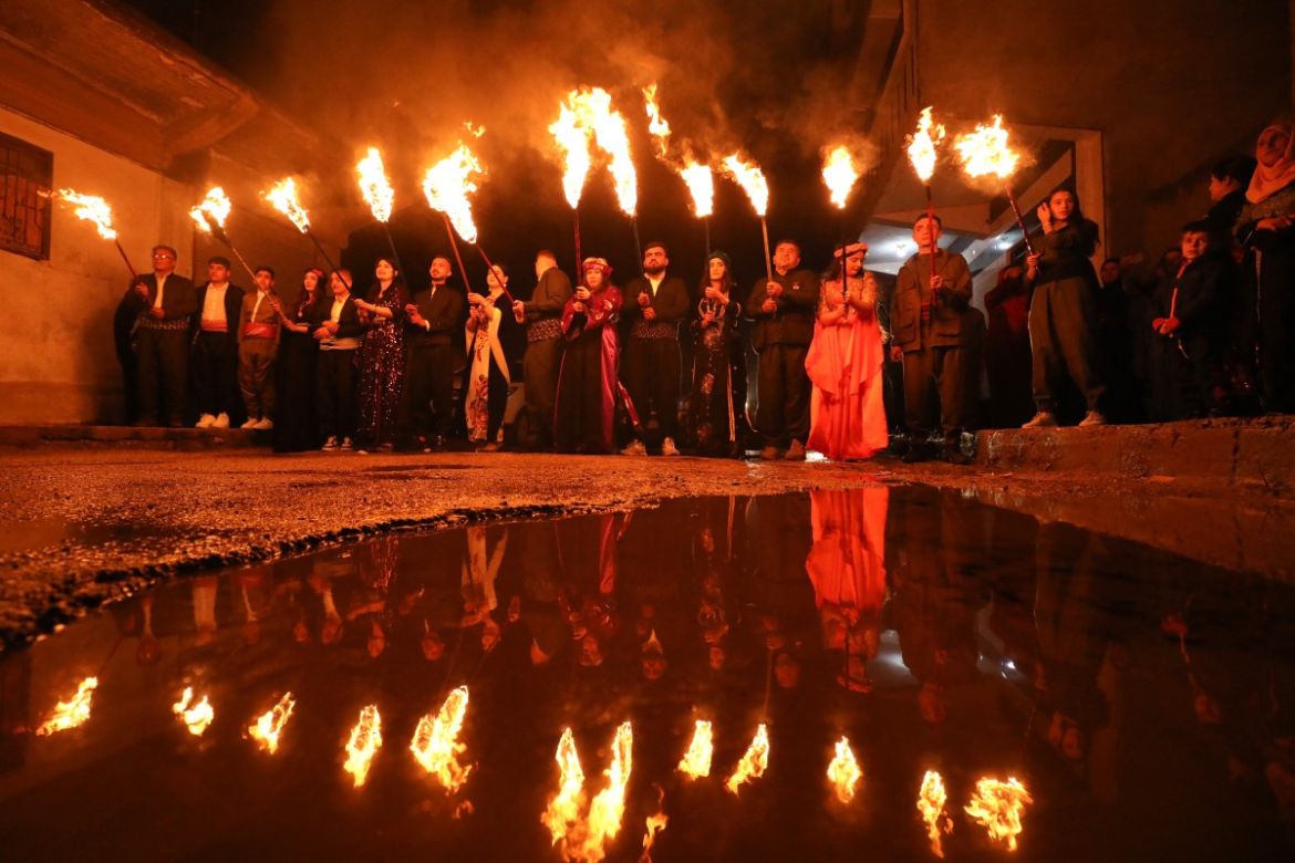 Syrian Kurds march with torches during the celebration of Nowruz, the Persian New Year, in the Kurdish-majority city of Qamishli in Syria's northeastern Hasakeh province,