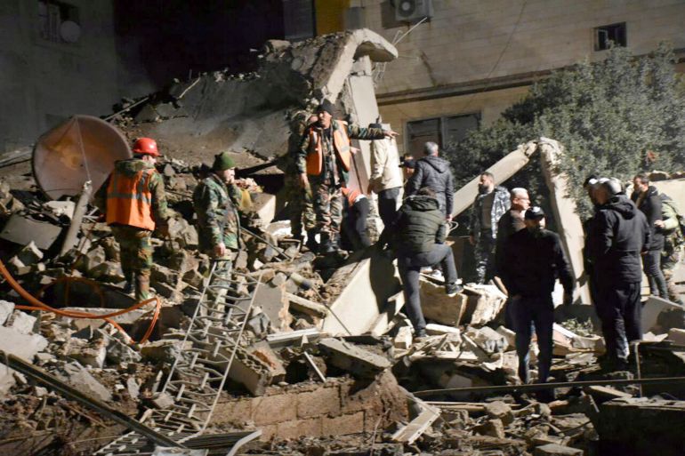 People gather to rescue others after Israeli airstrikes in Homs