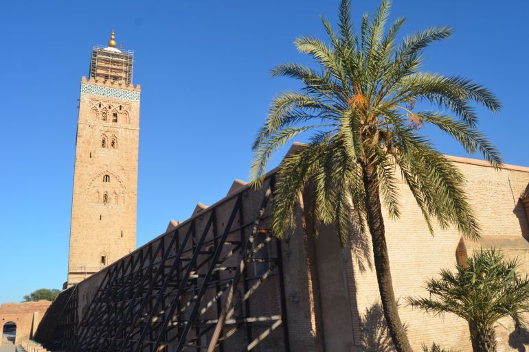 Koutoubia Mosque against a blue sky with scaffolding holding the walls up