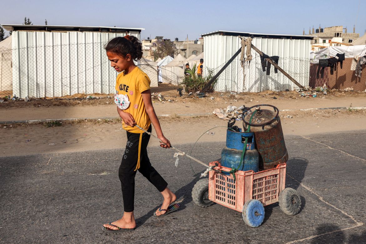 A girl pulls a cart loaded with gas cylinders along a street in Rafah in the southern Gaza Strip