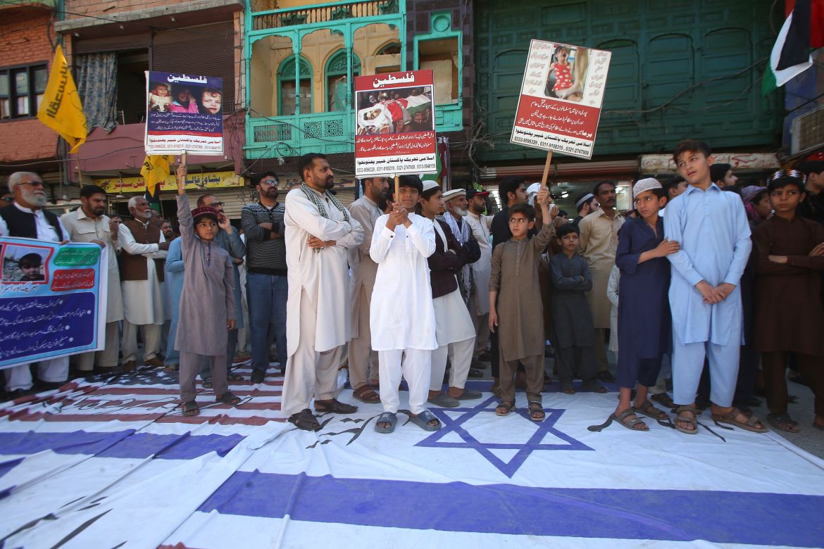 Shiite Muslims stand over the representations of U.S. and Israeli flags during the annual Al-Quds, or Jerusalem, Day demonstration in Peshawar, Pakistan