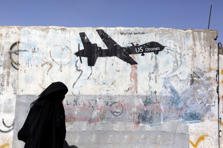 A woman walks past graffiti depicting a US drone in Sanaa, Yemen, in 2019. For decades, US drone attacks targeting armed groups have killed civilians in countries including Yemen and Somalia