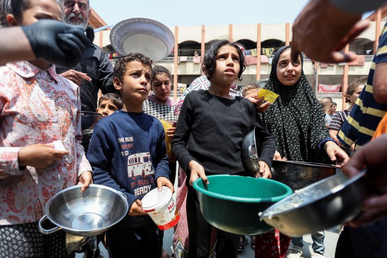 Palestinian children gather to receive meals from the charity World Central Kitchen in Deir el-Balah in the central Gaza Strip, on May 1