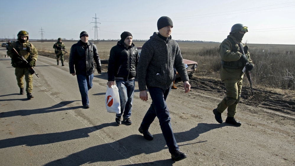 Pro-Russia separatists guard Ukrainian captives before an exchange of prisoners [Alexander Ermochenko/Reuters]