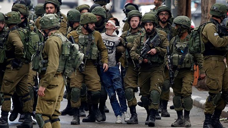 Israeli forces detain Palestinian Fevzi El-Junidi, 14-year-old, following clashes after protests against a decision by US President Donald Trump to recognize Jerusalem as the capital of Israel, in the