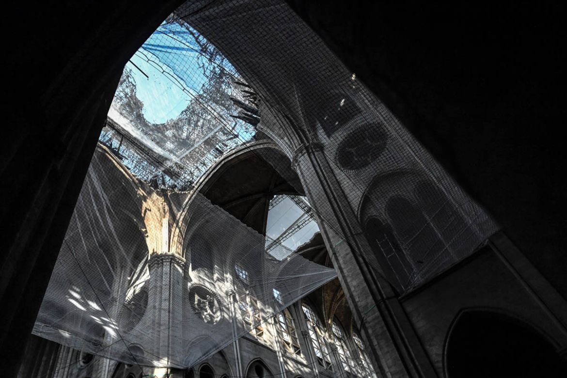 A part of the nave is seen through a safety net during preliminary work in the Notre-Dame de Paris Cathedral three months after a major fire on July 17, 2019 in Paris. French MPs on July 16 approved a