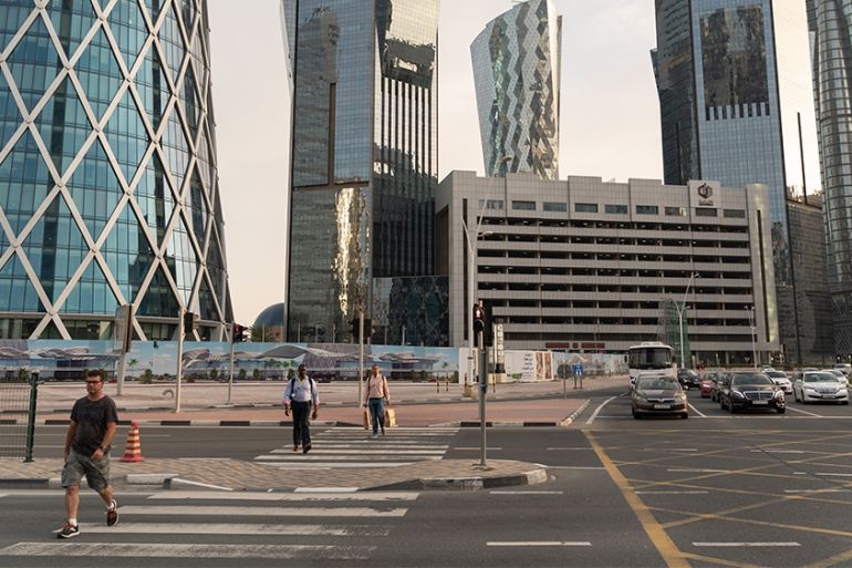 People walk in West Bay area in Doha, Qatar, March 25, 2020. Qatar has imposed a series of measures to contain the coronavirus outbreak, including closing of parks and public areas, banning social gat