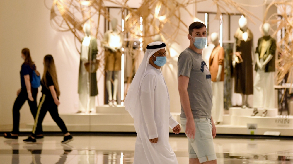 People wearing masks for protection against the coronavirus, walk in the Mall of Dubai on April 28, 2020, after the shopping centre was reopened as part of moves in the Gulf emirate to ease lockdown r