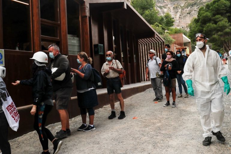 Visitors wearing protective face masks disinfect their hands as they enter to the Caminito del Rey (The King''s Little Pathway) as it reopens to the public under strict social distance measures after b