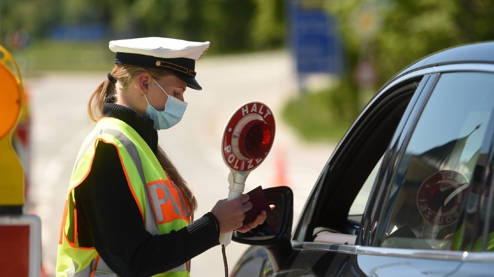 A German police officer wearing a protective mask during a car control at the border crossing between Austria and Germany, near the German village of Oberaudorf as Germany enforce