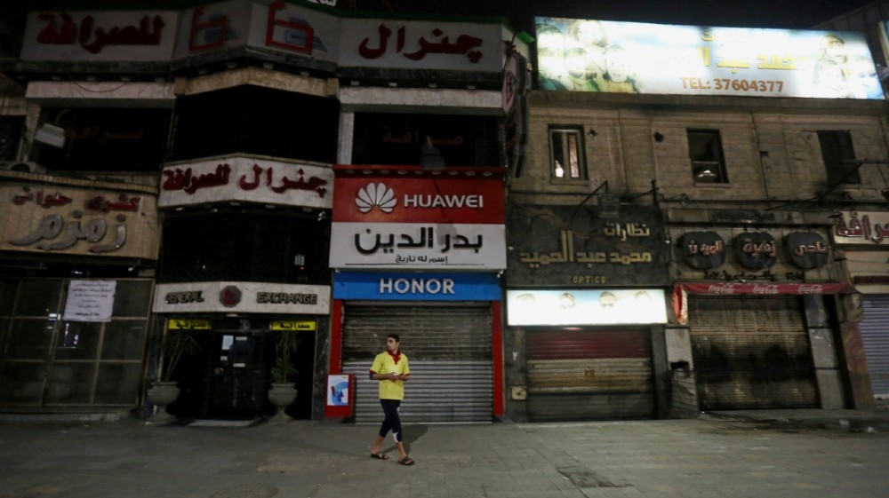 A man walks in front of closed shops, after Egyptian Prime Minister Mostafa Madbouly ordered all restaurants, cafes, cafeterias, night clubs, shopping malls and shops