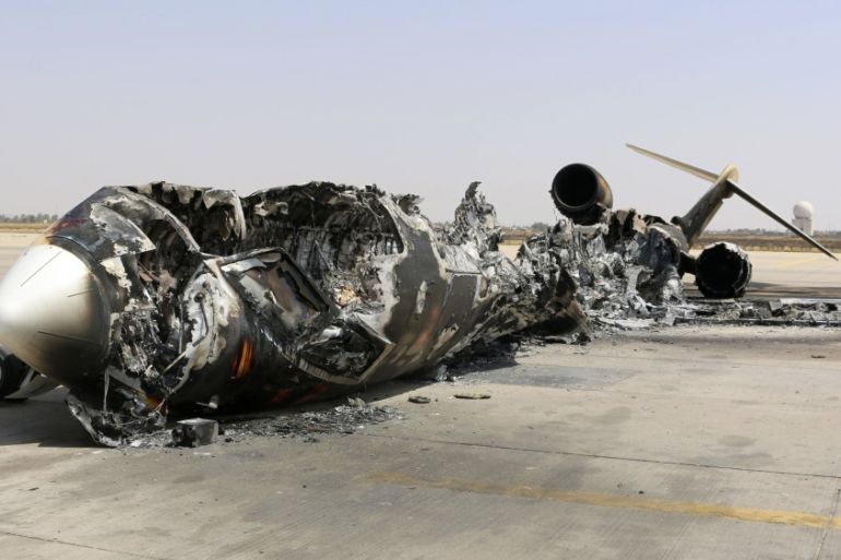 A wreckage of a burnt aircraft is pictured after a shelling at Tripoli International Airport