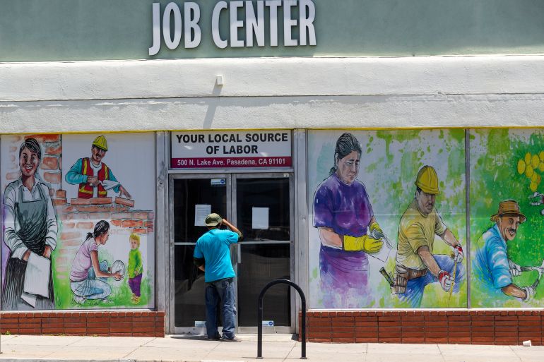 a person looks inside the closed doors of the Pasadena Community Job Center in Pasadena, California, US