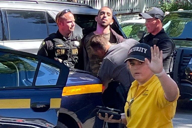Law enforcement officers detain Hadi Matar, 24 and take him to a police car outside the Chautauqua Institution 