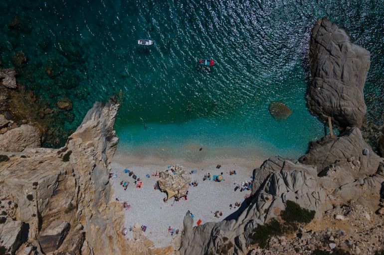 epa08616829 An image taken with a drone shows people enJoy their swimming in the beach 'Seychelles' in the island of Ikaria, Greece, 21 August 2020. EPA-EFE/DIMITRIS TOSIDIS