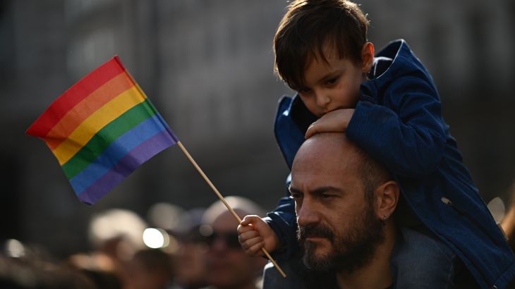 A man carries a boy on his shoulders during a demonstration by gay rights and civil society groups in Milan