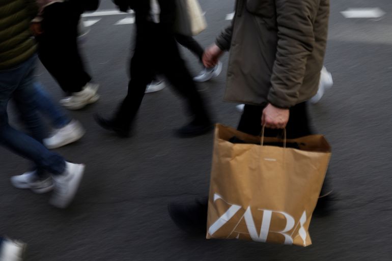 A man walks with a Zara bag