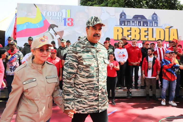 Venezuelan President Nicolas Maduro (C) and First Lady Cilia Flores arrive at a political rally in Caracas, on April 13