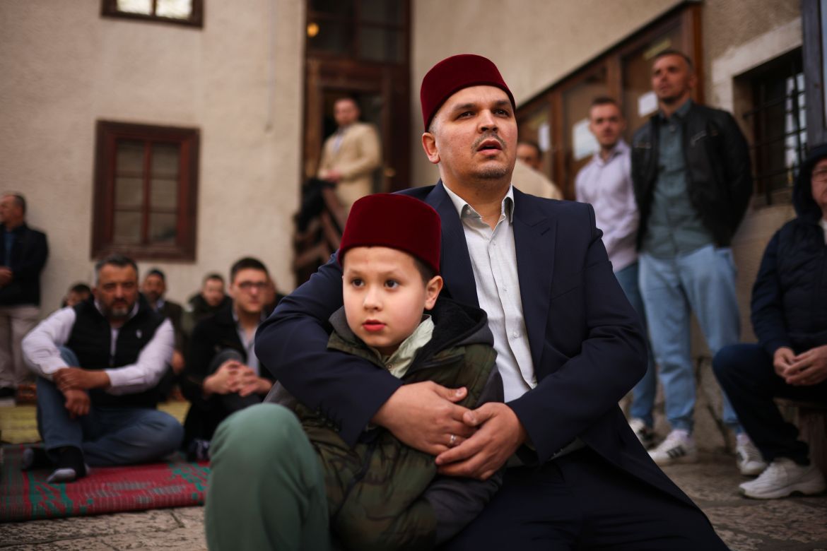 A Bosnian Muslim man prays with his son during the first day of Eid al-Fitr, which marks the end of the holy fasting month of Ramadan in Gazi Husrev-beg Mosque in Sarajevo
