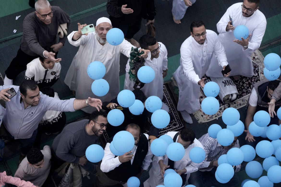 Muslims try to catch free balloons distributed during Eid al-Fitr, marking the end of the Muslim holy fasting month of Ramadan, outside al-Seddik mosque in Cairo