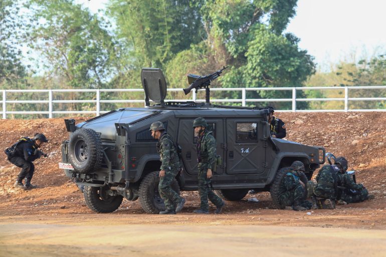 A Thai military armored vehicle takes a position with sounds of explosions and gunshots along the Moei river,