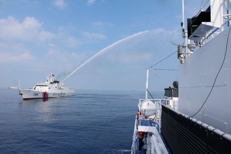 A Chinese coastguard ship firing water cannon at a Philippines coast guard ship