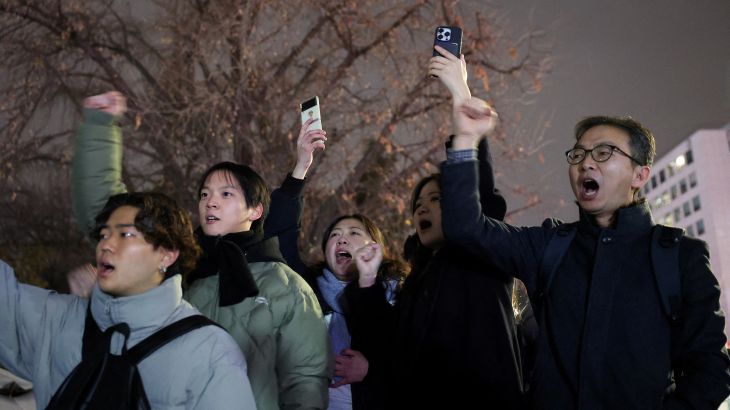 People shout slogans in front of the gate of the National Assembly