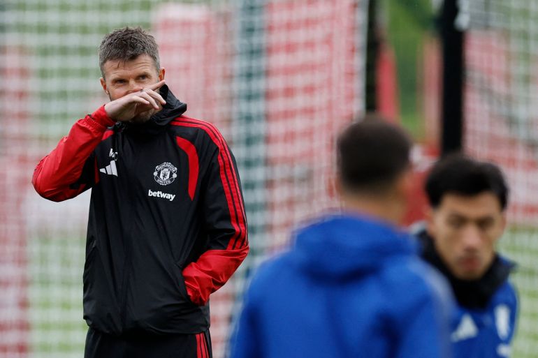 Manchester United manager Michael Carrick looks on as Lisandro Martinez, right, trains