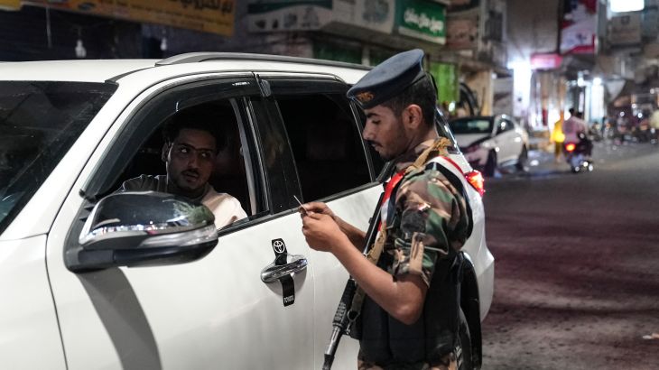 A member of the security forces of the internationally-recognised Yemeni government mans a checkpoint on a street in Taiz amid concerns over Houthi infiltration, late on September 27, 2026. Following several years of relative calm, Yemen's war reignited in July, against the backdrop of the widening Middle East war. Fighting intensified in September as the Houthis launched a lightning offensive that saw them seize Yemen's entire Red Sea coast, including the Bab al-Mandab Strait, a vital shipping lane. (Photo by AFP) /