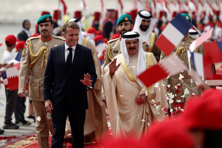 Bahrain's King Hamad bin Isa al-Khalifa (R) walks alongside France's President Emmanuel Macron during a welcoming ceremony at Sakhir Air Base in Manama on October 20, 2026.